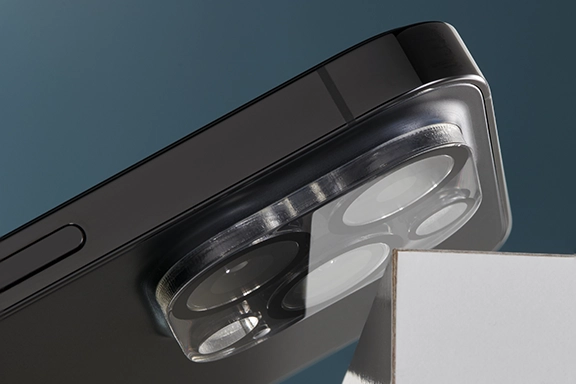 Die Rückseite eines Smartphones kracht mit der Kamera auf eine spitze Kante, das ist jedoch kein Problem, da die Kameras durch den Hama Kameraschutz "Cam Protect" mit 3 Einzellinsen geschützt werden.